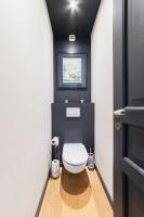 a bathroom with a white toilet in a black wall at Wonderful luxury house at 10min from Paris in Meudon