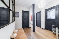 a hallway with black doors and wooden floors at Wonderful luxury house at 10min from Paris in Meudon