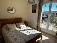 a bedroom with a bed and a large window at Marina Ivoire in Aigues-Mortes