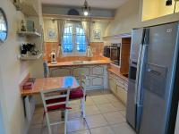 a kitchen with a table and a stainless steel refrigerator at Marina Ivoire in Aigues-Mortes