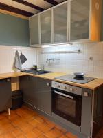 a kitchen with a stove and a sink at Appartement à Uriage les Bains. in Vaulnaveys-le-Haut