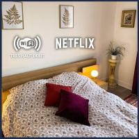 a bedroom with a bed with a netflix sign on the wall at Confort Parisien - parking gratuit - Chaleureux in Rueil-Malmaison