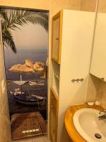 a bathroom with a sink and a view of the ocean at Confort Parisien - parking gratuit - Chaleureux in Rueil-Malmaison
