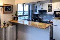 a kitchen with white cabinets and a counter top at Confort Parisien - parking gratuit - Chaleureux in Rueil-Malmaison