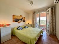 a bedroom with a green bed and a window at Appartement Les Issambres, 2 pièces, 4 personnes - FR-1-226-540 in La Garonnette-Plage