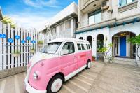 a pink and white van parked in front of a house at 晶藍色美人魚 Mermaid Inn in Hualien City