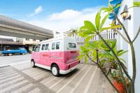 a pink and white van parked next to a building at 晶藍色美人魚 Mermaid Inn in Hualien City
