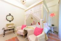a bedroom with a four poster bed with pink pillows at 晶藍色美人魚 Mermaid Inn in Hualien City