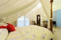 a bedroom with a canopy bed with a teddy bear on it at 晶藍色美人魚 Mermaid Inn in Hualien City
