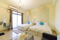 a bedroom with two beds and a chandelier at 晶藍色美人魚 Mermaid Inn in Hualien City