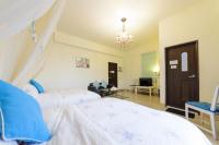 a bedroom with two beds and a chandelier at 晶藍色美人魚 Mermaid Inn in Hualien City