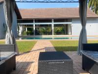 Un patio con dos bancos y una piscina. en Lion Gate Hotel Sigiriya, en Sigiriya