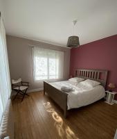 a bedroom with a large bed and a purple wall at La Maison des phares in Lion-sur-Mer