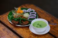 a plate of food with a bowl of soup on a table at Brown Town Resort & Spa in Hyderabad
