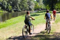deux garçons à vélo sur un sentier à côté d&#39;une rivière dans l&#39;établissement Camping Les Mijeannes, à Rieux-de-Pelleport
