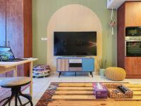 ein Wohnzimmer mit einem großen TV und einem Tisch in der Unterkunft Rustic Elegance By The Lake Studio Cabin In Jlt in Dubai