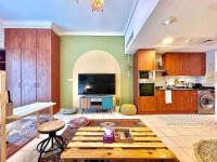 ein Wohnzimmer mit Tisch und Küche in der Unterkunft Rustic Elegance By The Lake Studio Cabin In Jlt in Dubai