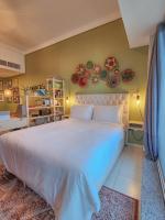 ein Schlafzimmer mit einem großen weißen Bett mit Platten an der Wand in der Unterkunft Rustic Elegance By The Lake Studio Cabin In Jlt in Dubai