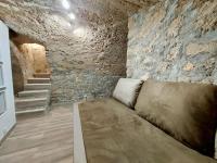 a couch in a room with a stone wall at T2 Atypique en centre-ville in Aix-en-Provence