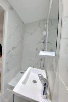 a white bathroom with a sink and a mirror at T2 Atypique en centre-ville in Aix-en-Provence