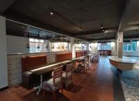 ein Restaurant mit Tischen und Stühlen und eine Bar in der Unterkunft Lazo Avarta Resort and Convention Centre Pondicherry in Kālapettai