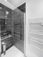 a bathroom with a shower with black tiles at Perle de la Loire in Blois
