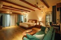 a bedroom with a bed and a living room at Vyna Hillock Resort in Vythiri