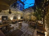 een patio met tafels, stoelen en verlichting bij LE PATIO in Grignan