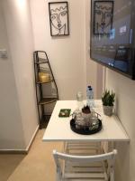a table with a chair and a tv on a wall at Boutique Suite Talia in Eilat
