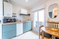 a kitchen with blue cabinets and a wooden table at Nid douillet entre Paris et Disney in Vaires-sur-Marne