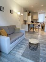 ein Wohnzimmer mit einem Sofa und einem Tisch in der Unterkunft Verger - Parking gratuit - Calme in Chambéry
