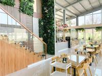 a restaurant with tables and chairs and plants on the wall at At Pream&Chan resort แอท เปรมแอนด์จันทร์ รีสอร์ท in Ban Krasang