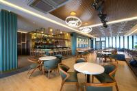 ValStar Hotel Canggu في تشانغو: مطعم به طاولات وكراسي وبار