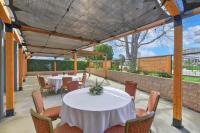 a patio with tables and chairs and a fence at Hilton Irvine/Orange County Airport in Irvine