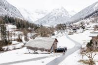 a snow covered village with a car driving down a road at Haus Kella-Egg in Brand