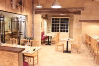 ein Restaurant mit Tischen und Stühlen in einem Raum in der Unterkunft Camping Le Pressoir in Petit-Palais-et-Cornemps