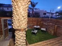 eine Palme auf einer Terrasse mit Tisch und Stühlen in der Unterkunft Shalom&#39;s place in Eilat