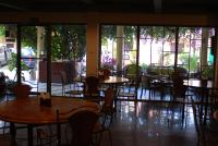 een leeg restaurant met tafels, stoelen en ramen bij shillahotel and resort in Angeles