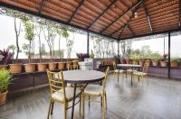 um pátio com mesas, cadeiras e plantas em PRIME SUITES em Bangalore