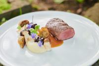 Hotel Agnesen-Hof في Barweiler: طبق ابيض فيه قطعة لحم وخضروات