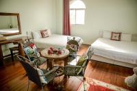 a room with two beds and a table and chairs at Alps Garden B&amp;B in Wujie