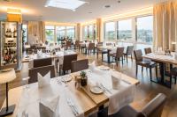 Un restaurante con mesas, sillas y ventanas. en Hotel Swiss Star, en Wetzikon