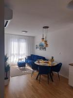 Una sala de estar con un sofá azul y una mesa. en Salona Lux, en Klis