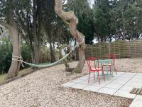 a table and chairs next to a tree with a hose at Mas de la pie in Saintes-Maries-de-la-Mer