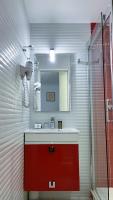 a bathroom with a red sink and a shower at Hôtel La Sanguine in Paris