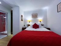 a bedroom with a red bed with two red pillows at Hôtel La Sanguine in Paris