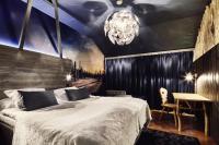 a bedroom with a large bed and a chandelier at Original Sokos Hotel Vaakuna Rovaniemi in Rovaniemi