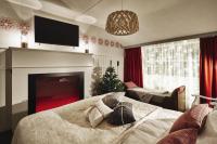 a living room with a fireplace and a christmas tree at Original Sokos Hotel Vaakuna Rovaniemi in Rovaniemi