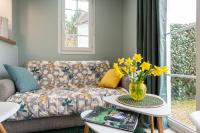 a living room with a couch and a vase of yellow flowers at Belle Dune in Fort-Mahon-Plage