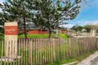 a wooden fence with a tree behind it at Belle Dune in Fort-Mahon-Plage